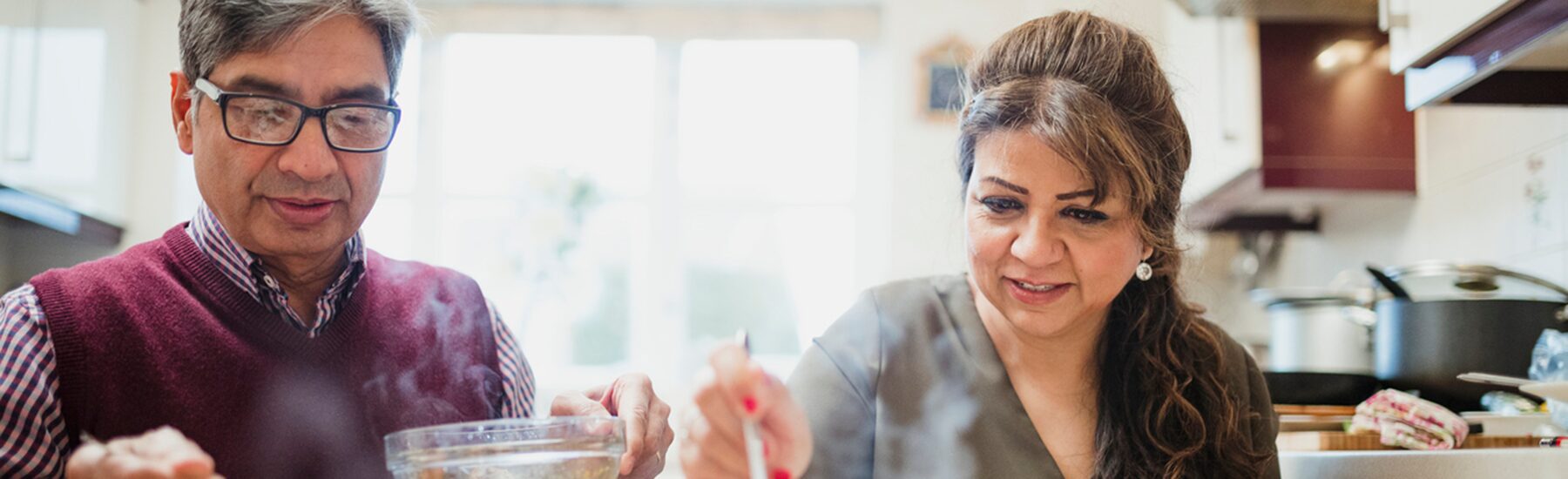 Older south Asian couple eating a meal at home