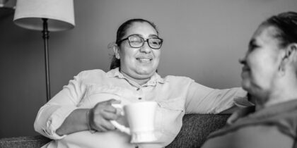 Black-and-white shot of two woman chatting over a cup of tea